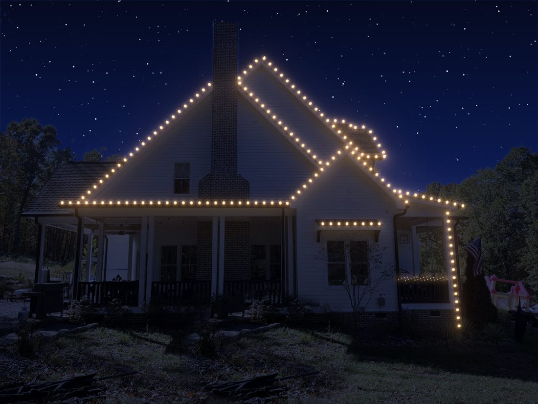 A large house with C9s outlining every roofline and lit trees.