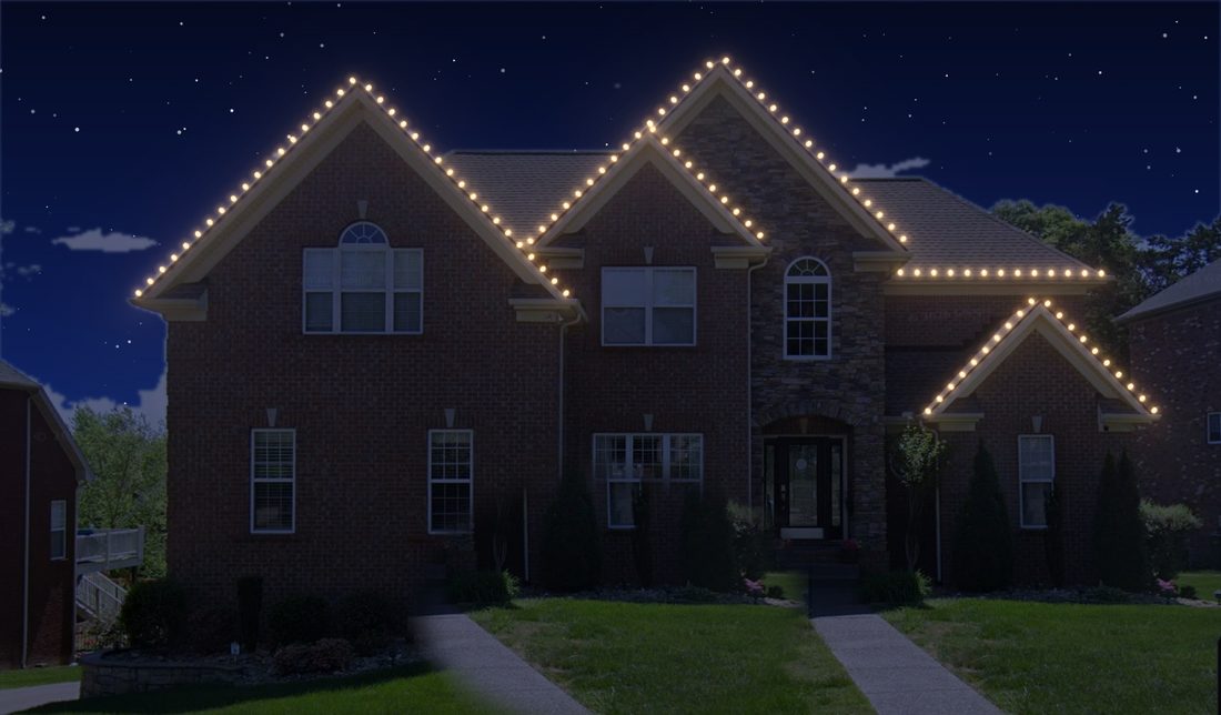 A brick home with C9s along each peak.