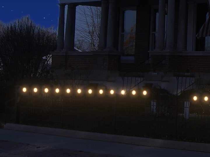 C9 lights along an iron fence.