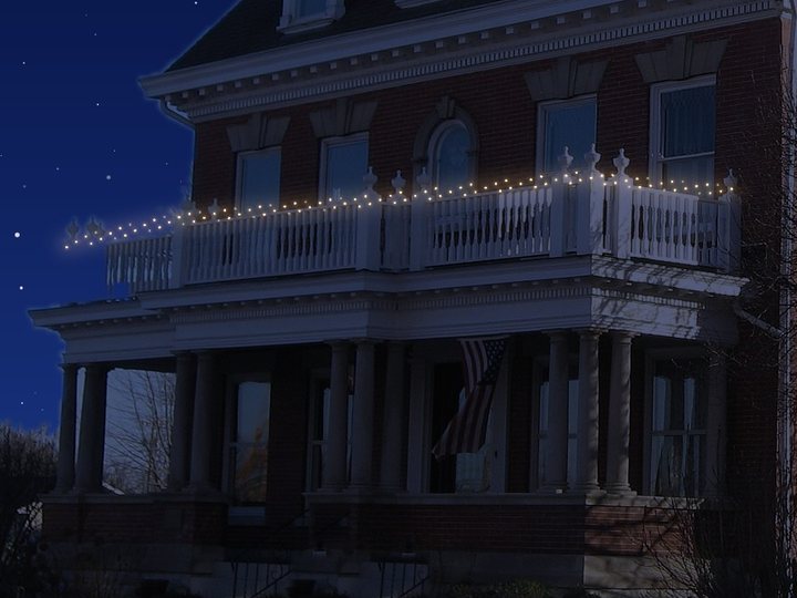 A balcony railing wrapped in mini lights.